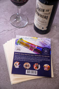 Load image into Gallery viewer, Contents of 100 Pack of Treasured Wine - Wine Label Remover Kit with leaflet and wine label remover sheets next to wine glass and wine bottle featuring Train to Nowhere Shiraz from the McLaren Vale wine region