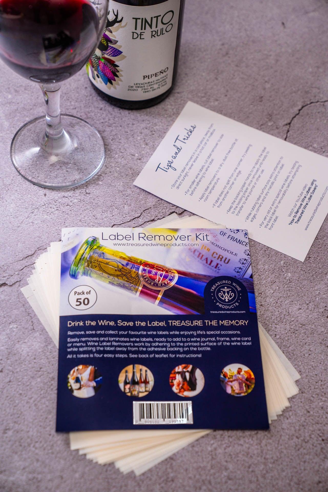 Contents of 50 Pack of Treasured Wine - Wine Bottle Label Remover Kit with leaflet and wine label remover sheets and Tips & Tricks, how to remove wine labels,  next to wine glass and wine bottle featuring Tinto de Rulo Pipeno wine from Chile wine region