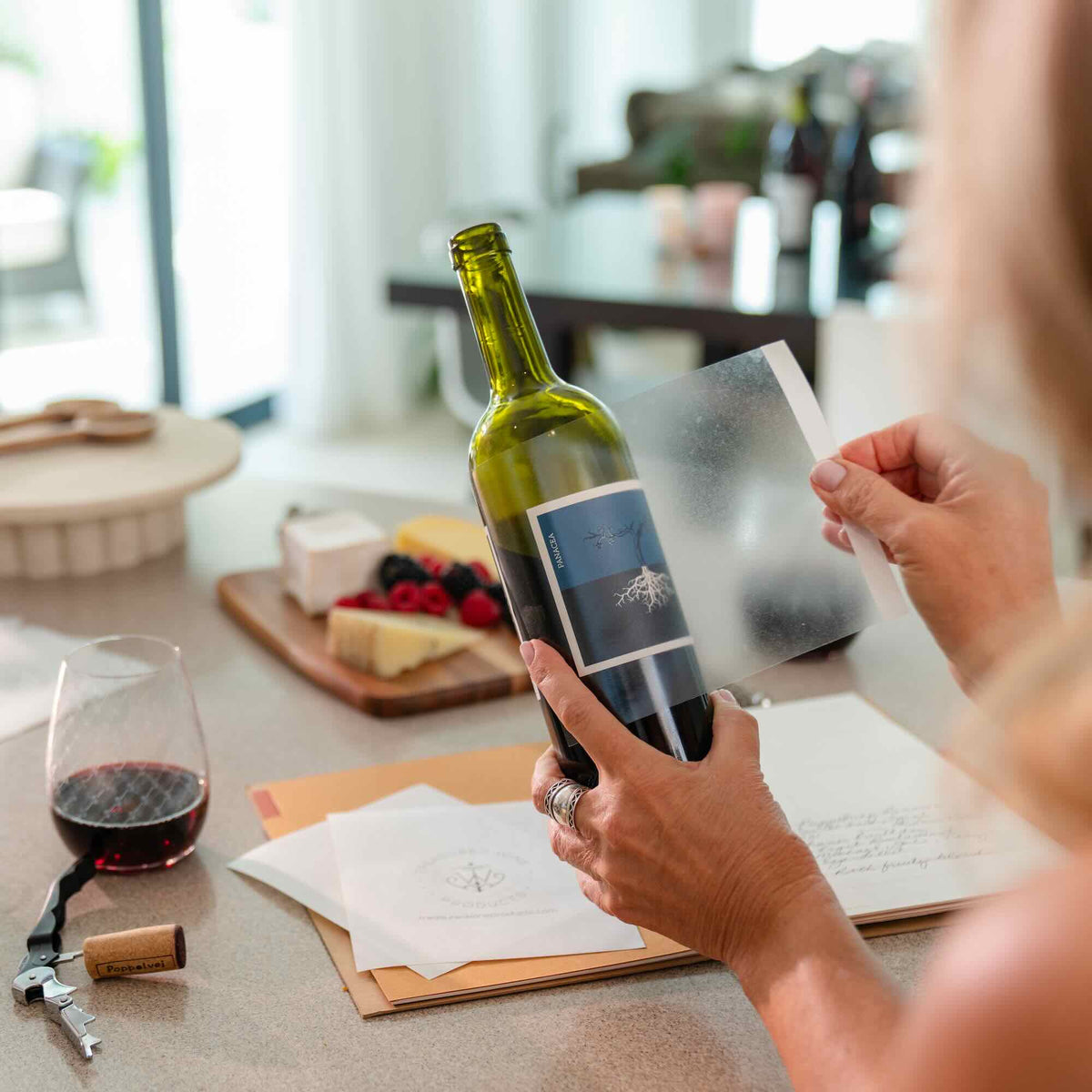 Person placing a wine label remover over a wine label preparing to remove the wine label