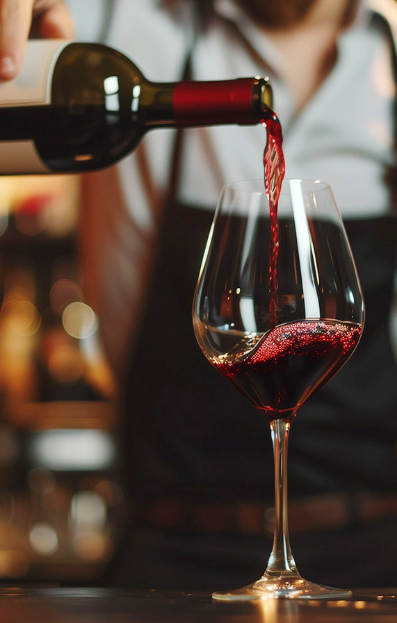 *Close up red wine pouring into glass